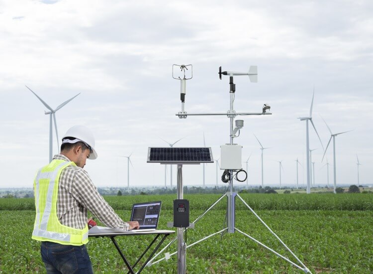 profissional em um campo aberto faz a análise de dados gerados por sensores na agricultura