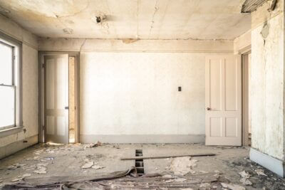 interior de uma casa toda em branco com entulho de obra após movimentações de início de reforma
